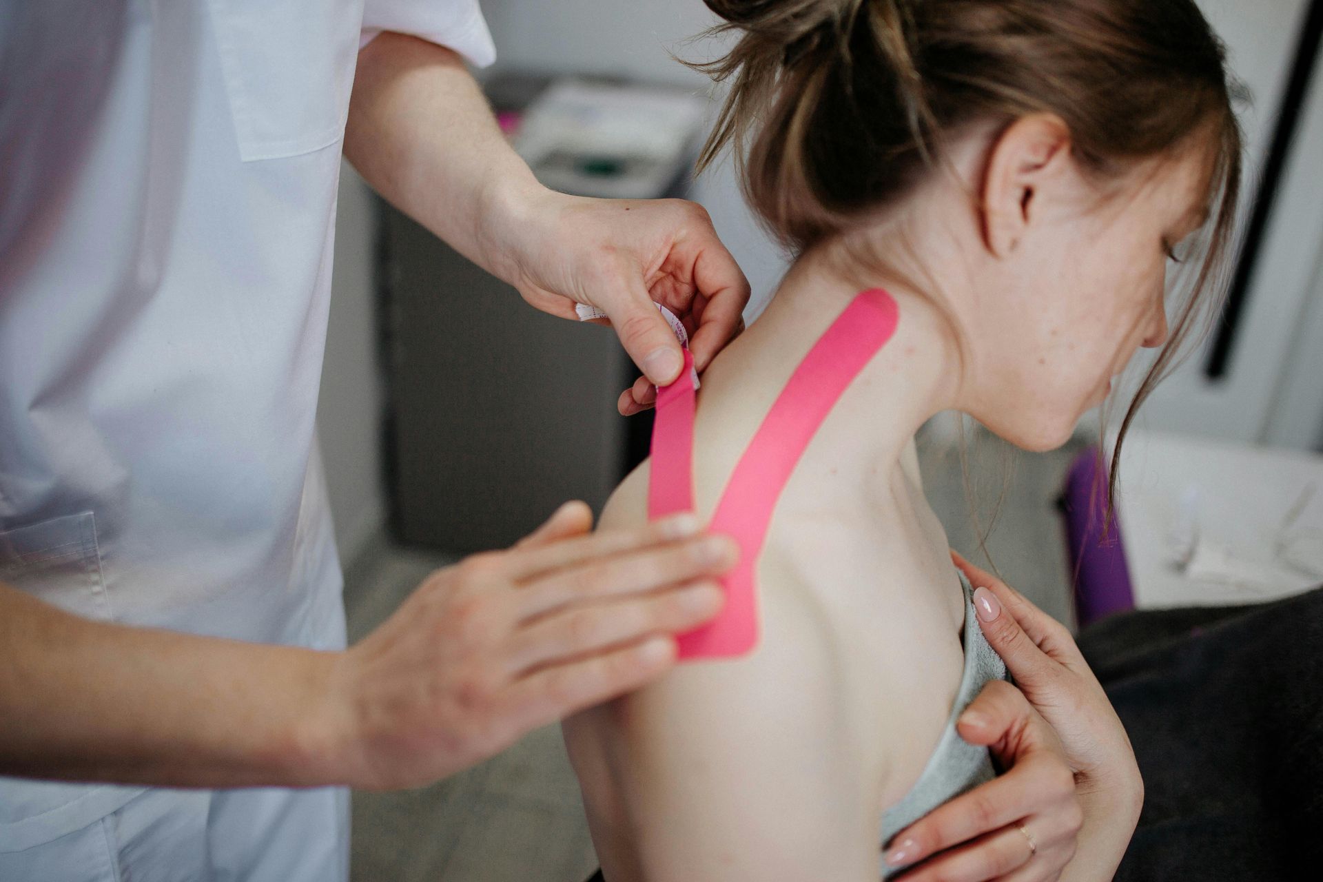 A Woman Is Getting Kinesio Tape on Her Neck — Burwood Back Pain in Strathfield, NSW