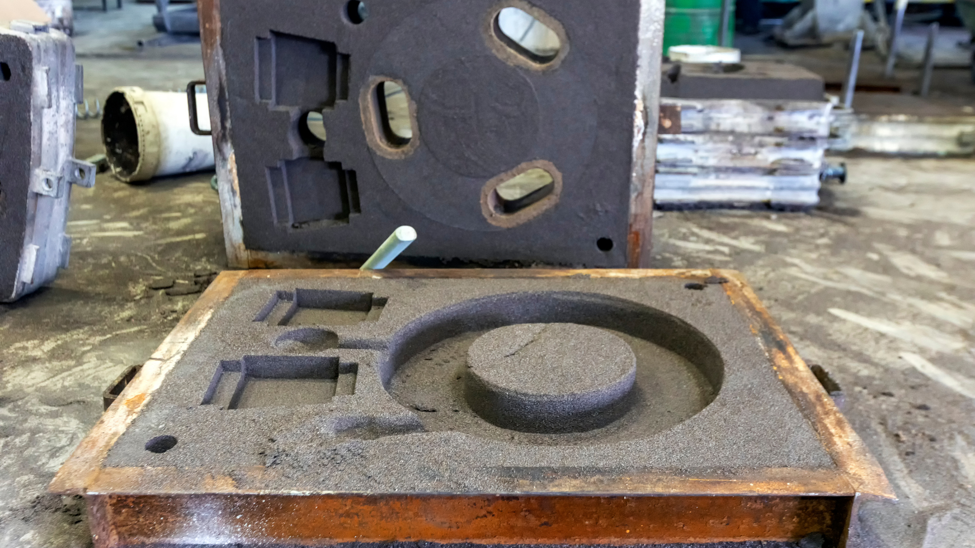 Welding sparks on metal rods held by a gloved hand, with bright arc light in a workshop.