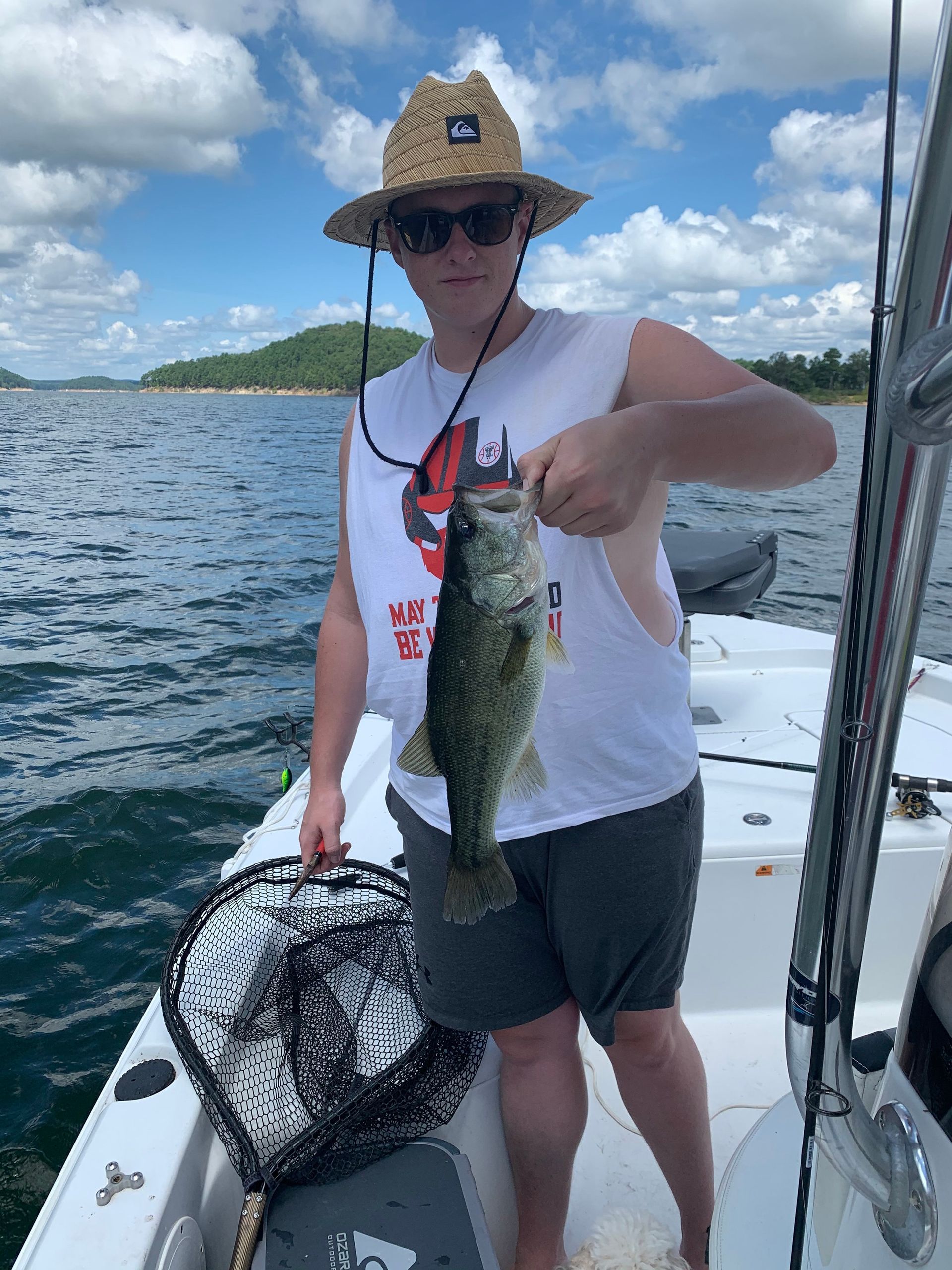 A man is standing on a boat holding a fish.