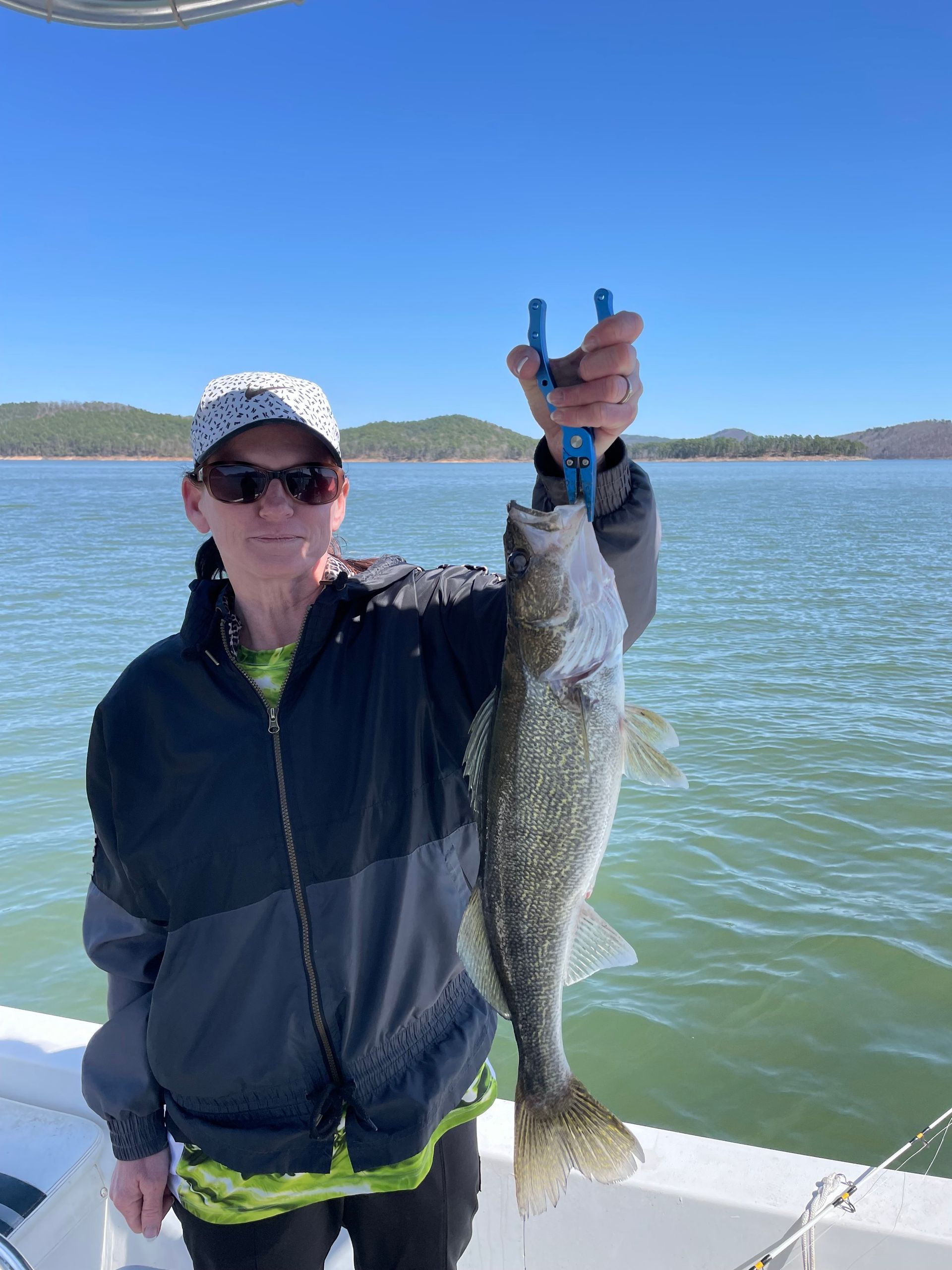 A man is holding a large fish on a boat.