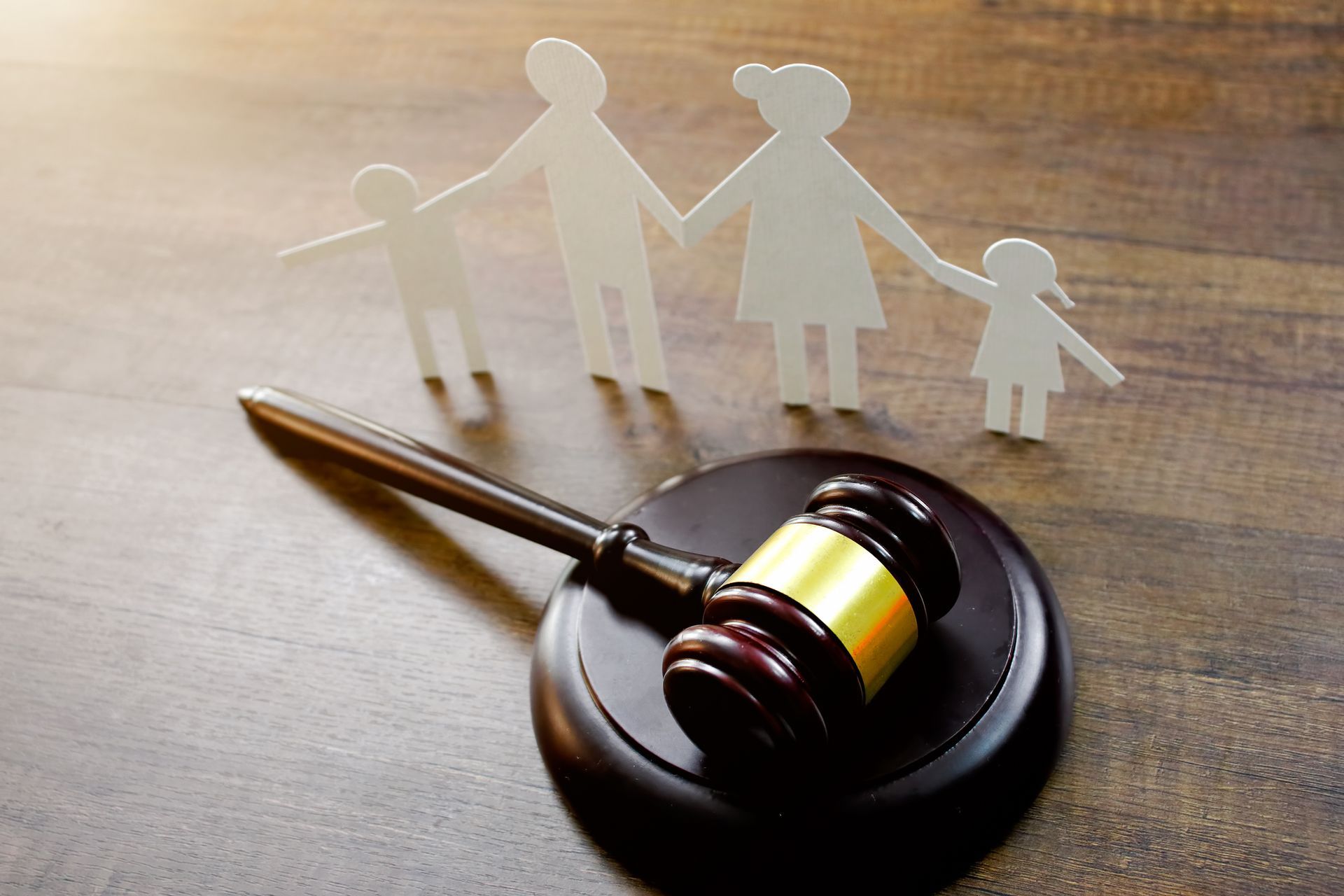 Family Attorney concept with gavel and paper cutout family, symbolizing legal protection and rights.