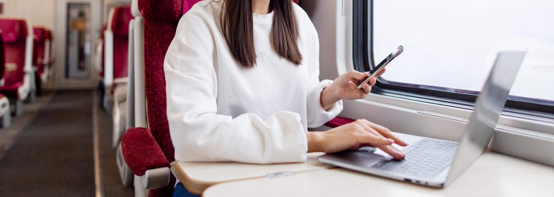 Picture of a woman using her laptop on a train. Picture of a woman using her laptop on a train.