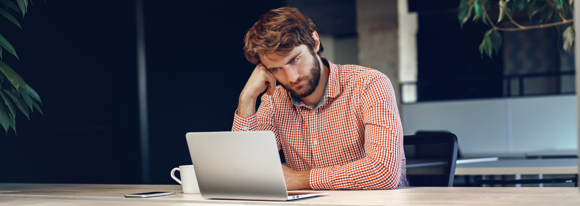 Picture of a man looking confused on a laptop. 