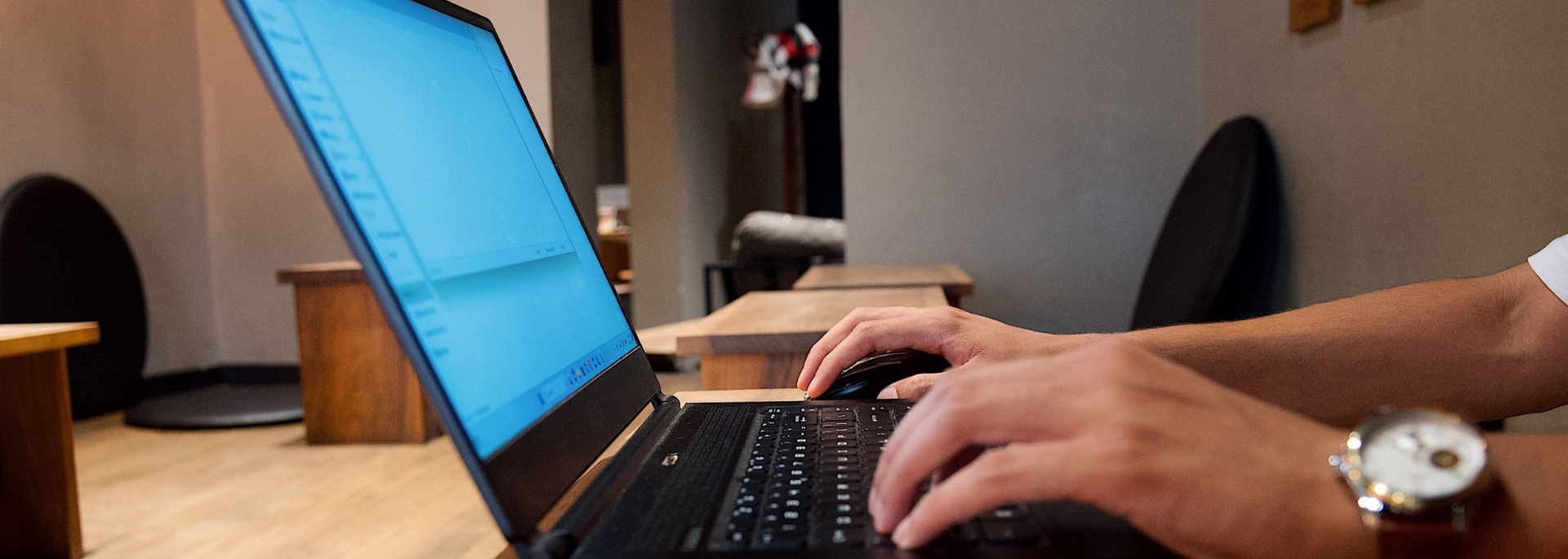 Picture of the back of a man on a laptop. 