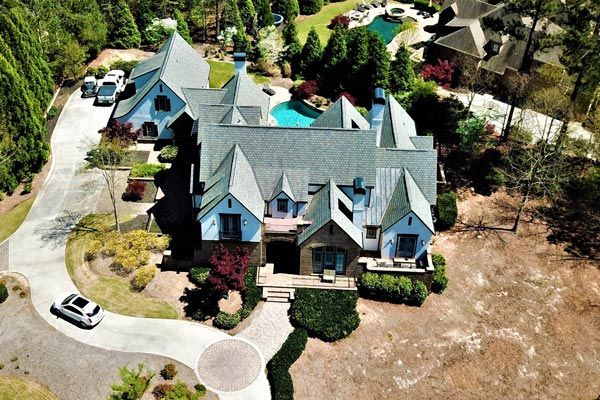An aerial view of a large house with a car parked in front of it.