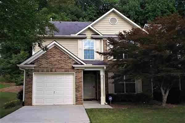 A large house with a garage and a driveway in front of it.
