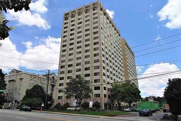 A tall building is sitting on the side of a city street.