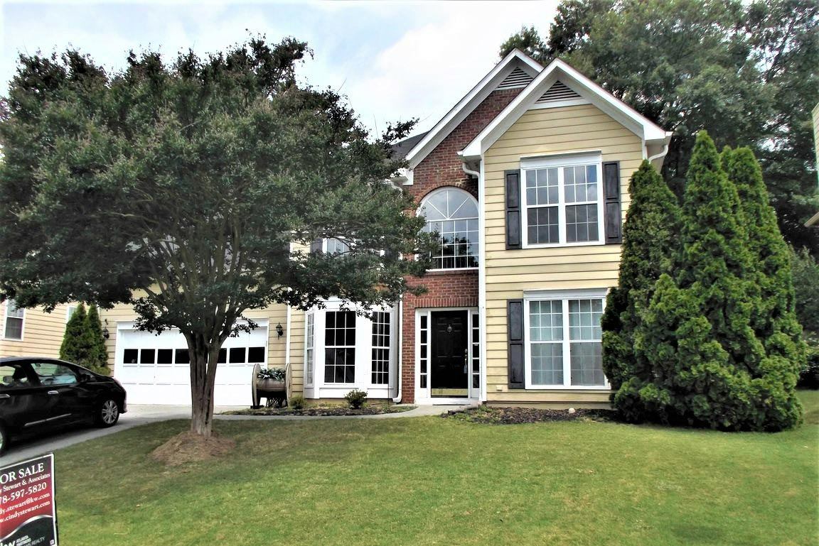 A large house with a lot of windows and a car parked in front of it.