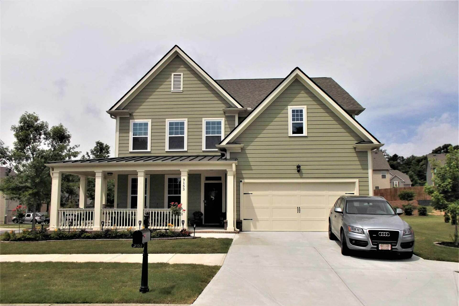 A large house with a car parked in front of it.