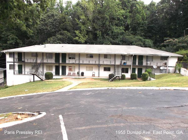 A large apartment building with a parking lot in front of it