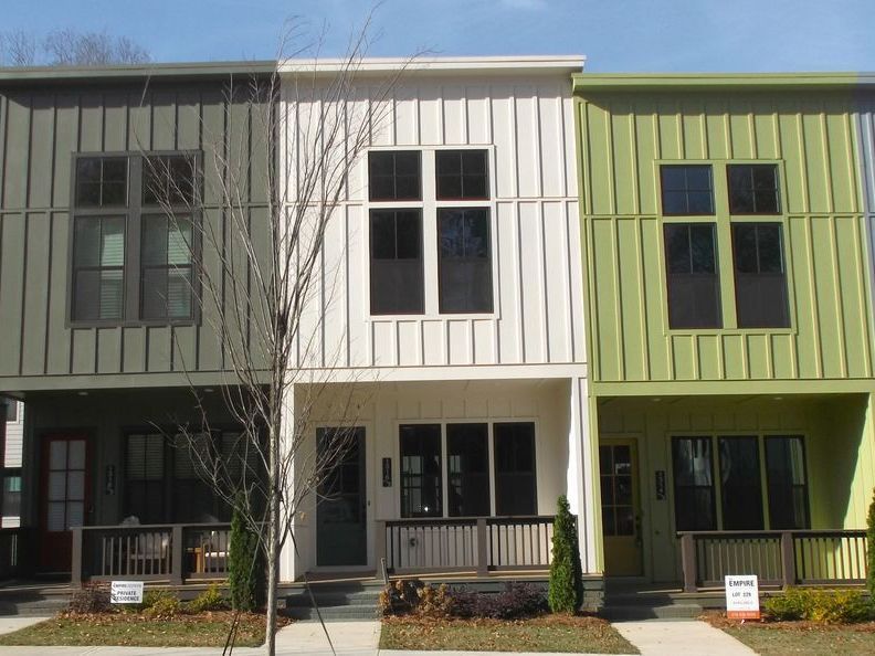 A row of houses with green and white siding