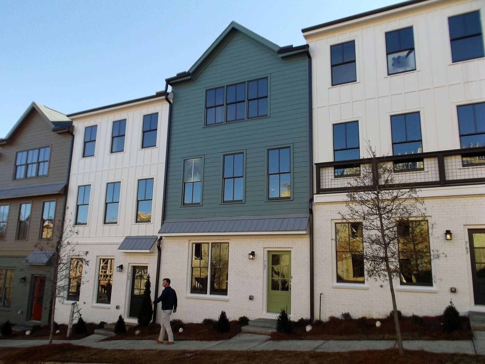 A man walking in front of a row of houses