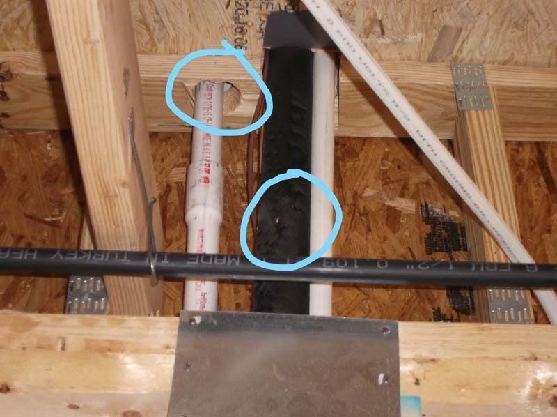 A picture of a ceiling with circles around the pipes