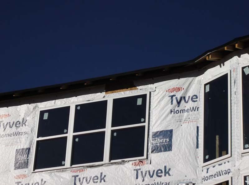 A building under construction with tyvek covering the windows