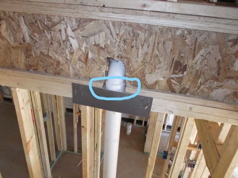 A pipe is being installed in a house under construction.