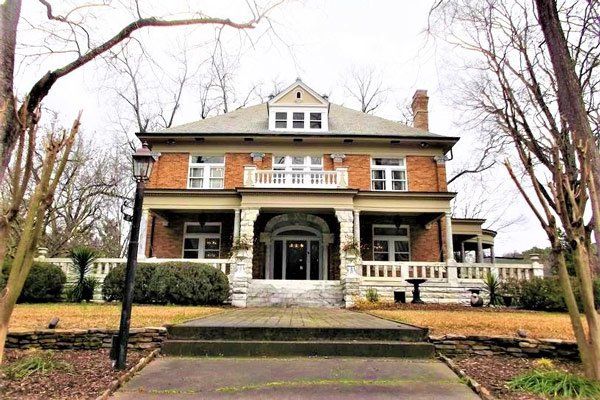 A large brick house with a porch and stairs