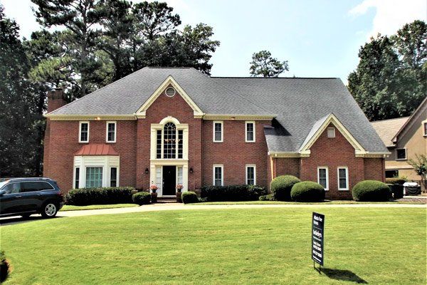 A large brick house with a car parked in front of it