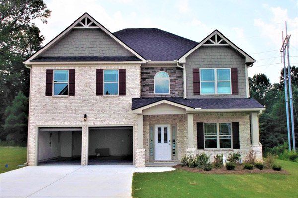 A large brick house with a gray roof and black shutters