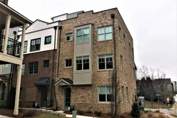 A large brick building with a lot of windows and a balcony.