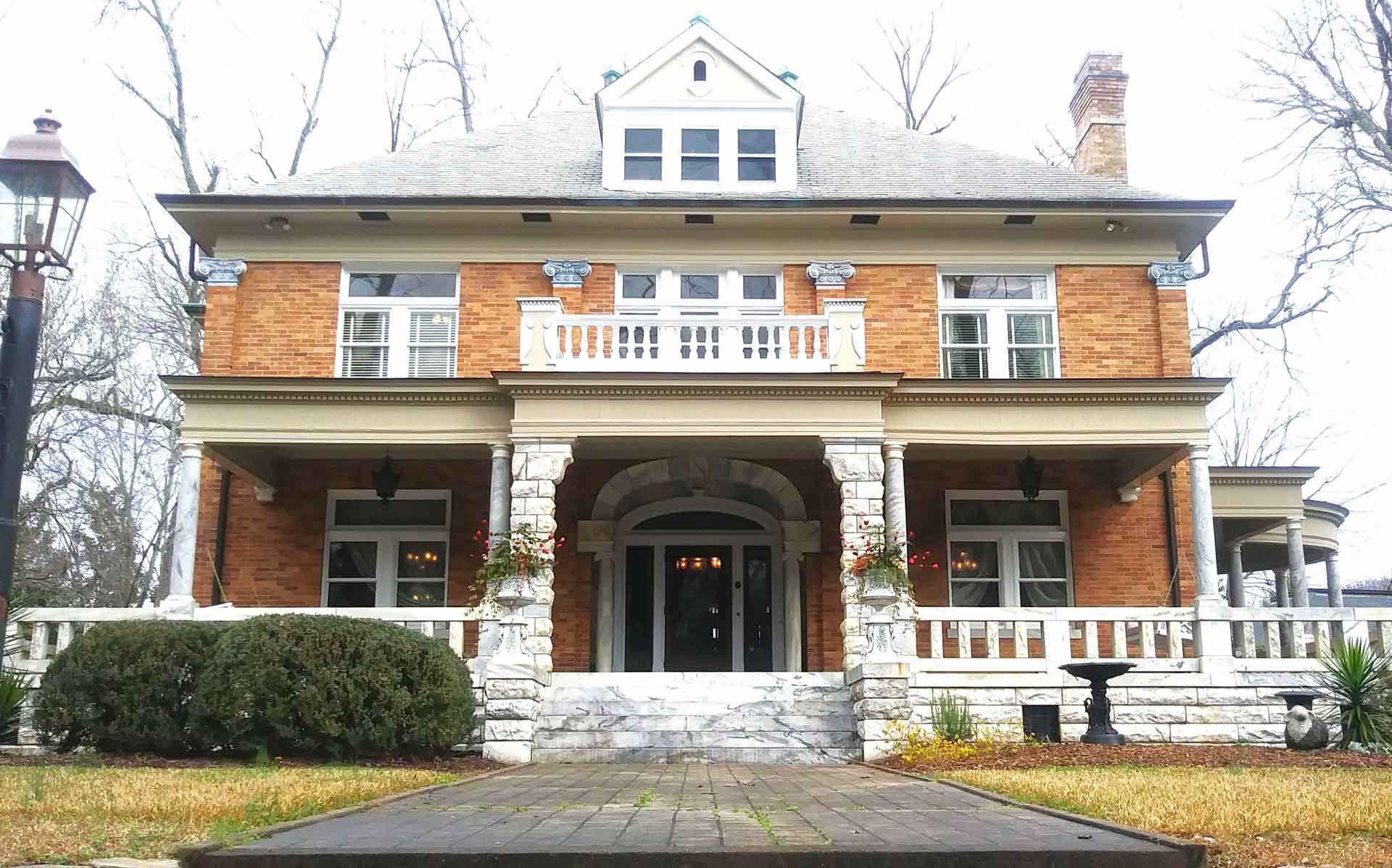 A large brick house with a large porch