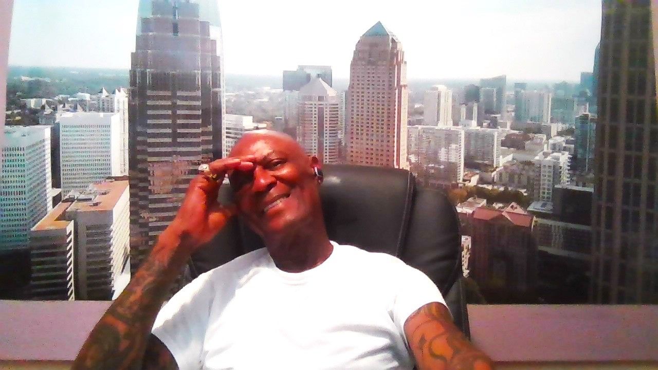 A man sitting in a chair talking on a cell phone