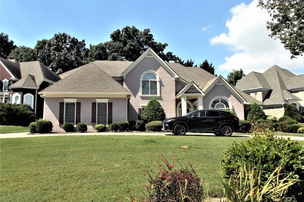 A black suv is parked in front of a large house