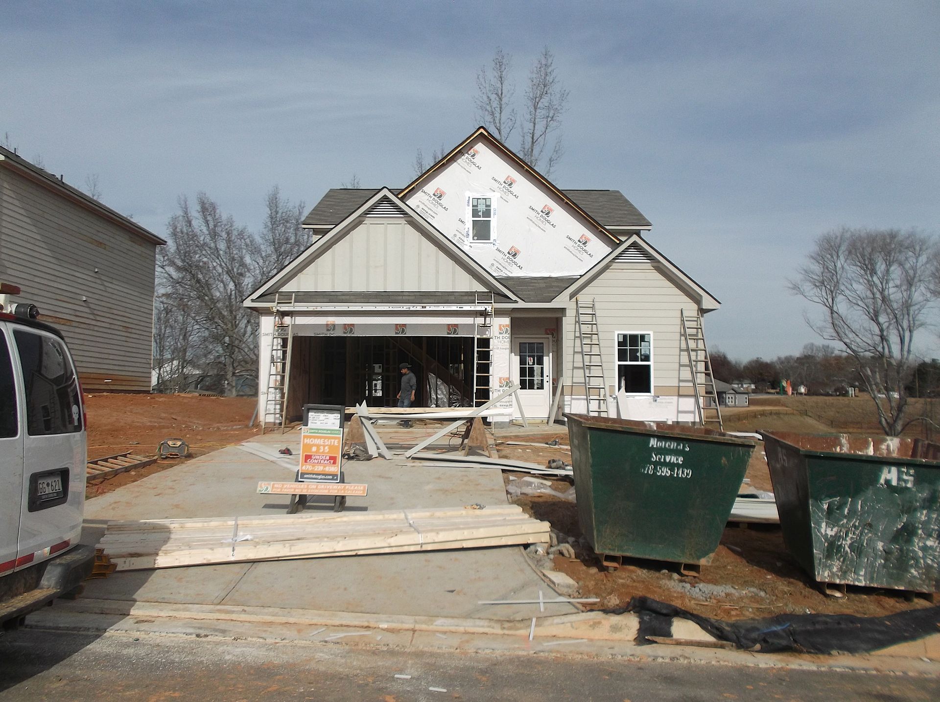 A van is parked in front of a house under construction