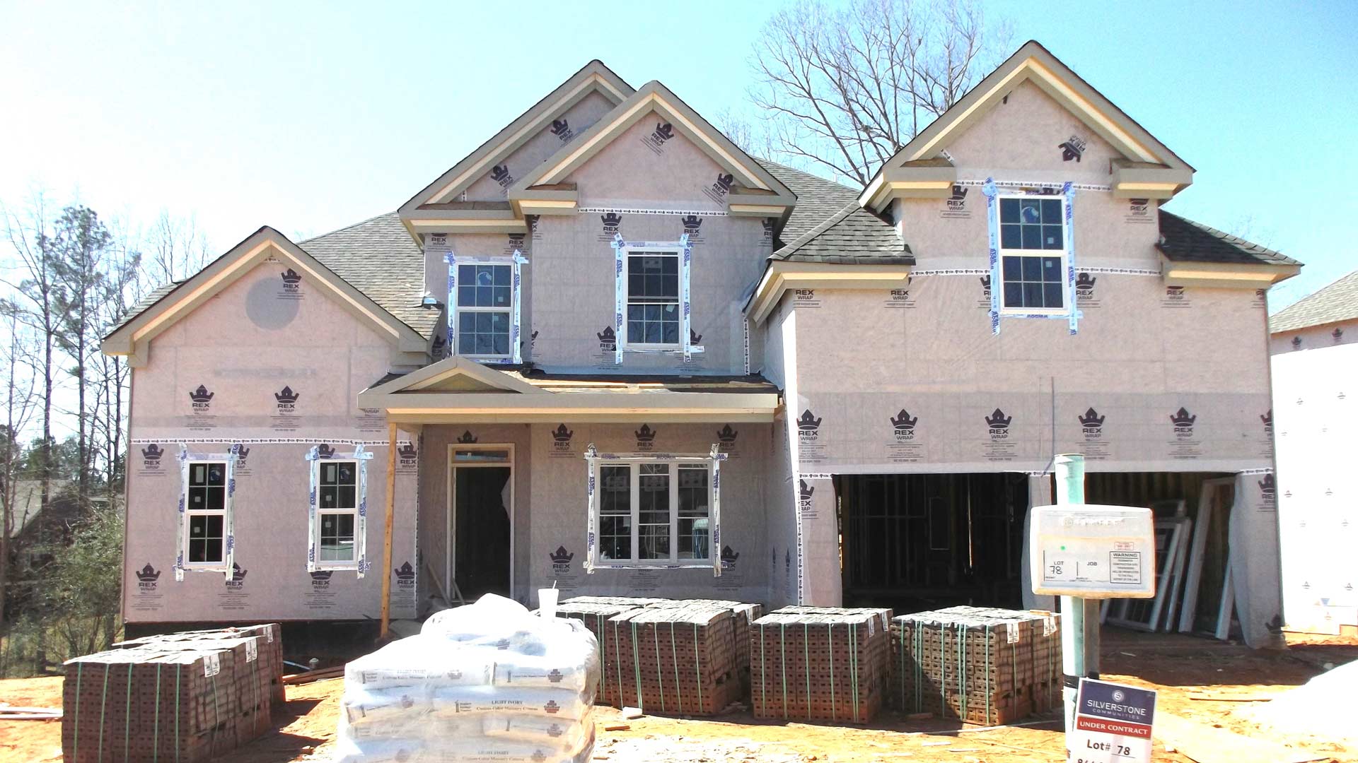 A house under construction with a mailbox in front of it