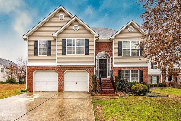 A large house with two garages and a driveway in a residential area.