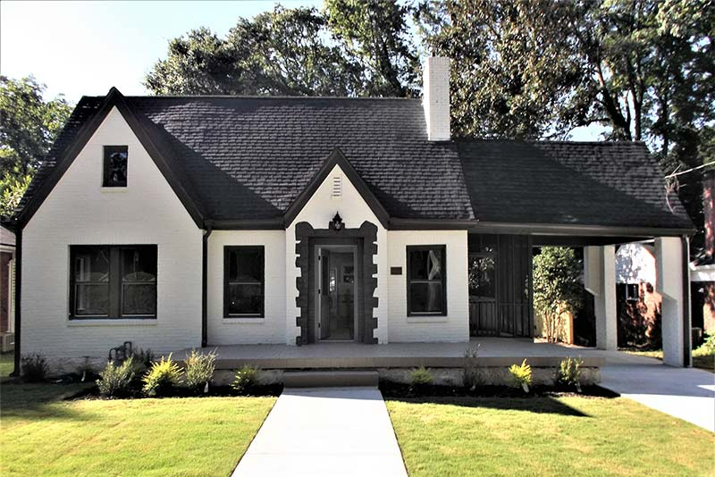 A white house with a black roof and a porch