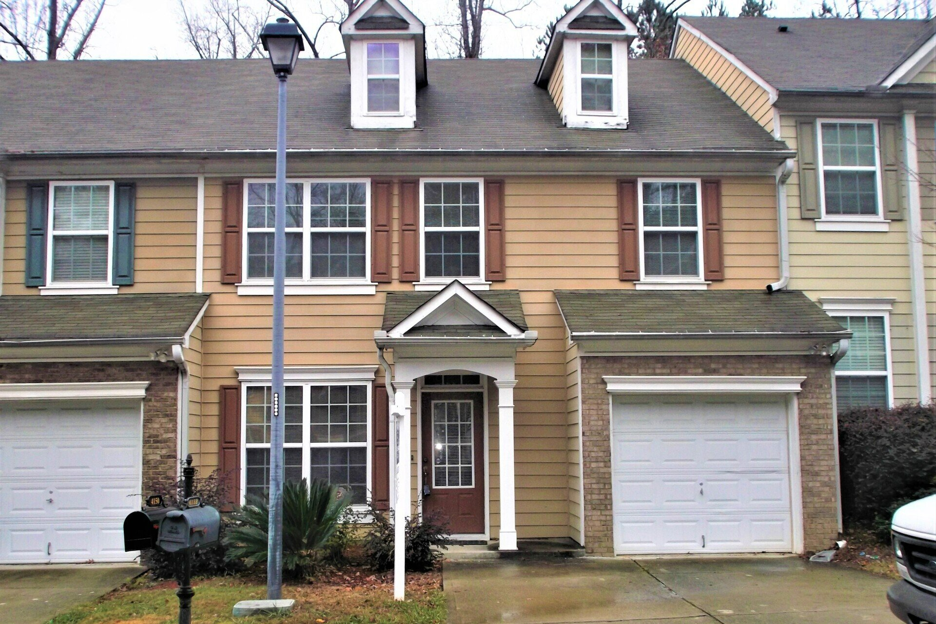 A house with two garages and a mailbox in front of it