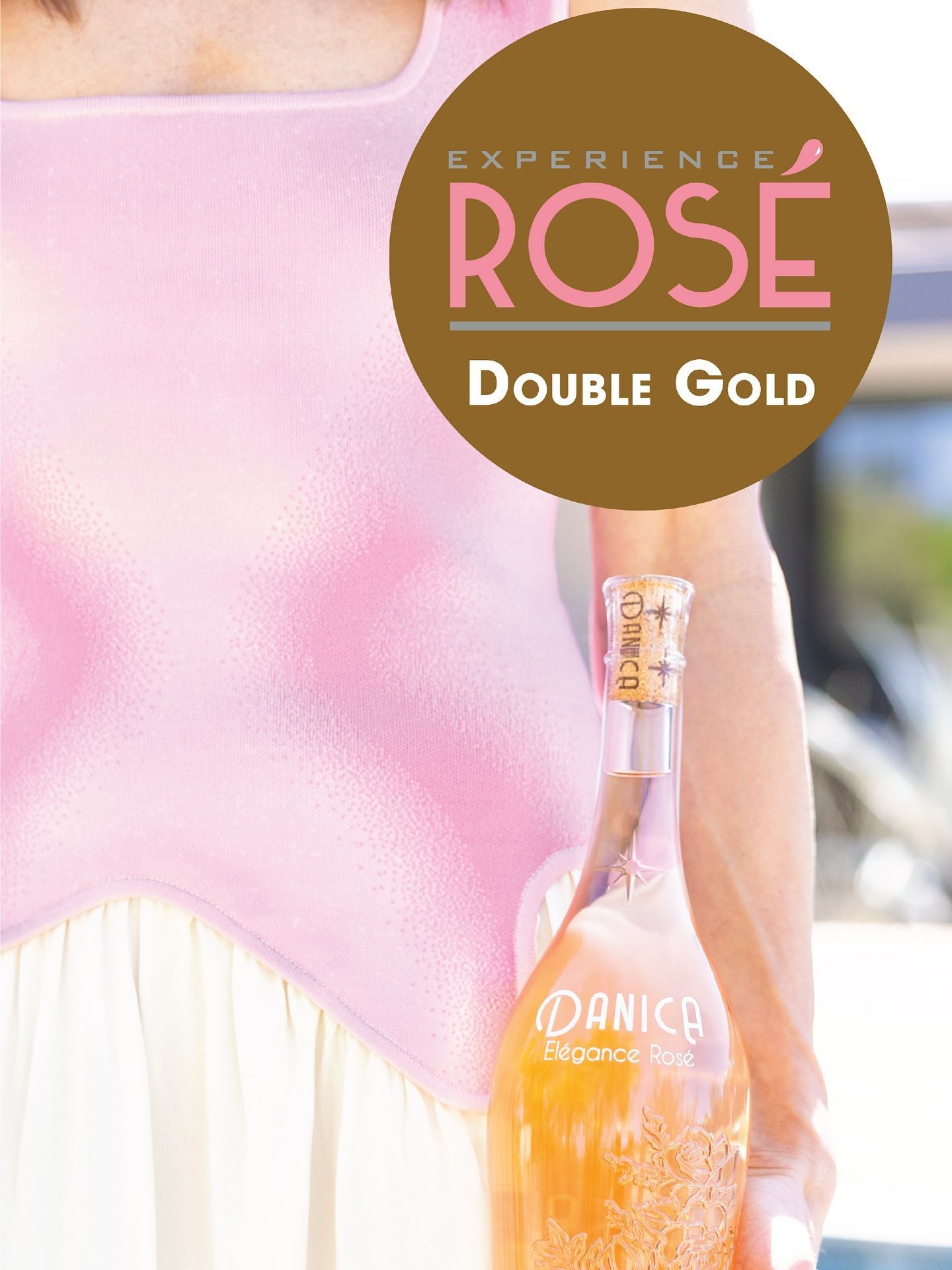 Woman holds a bottle of pink sparkling rosé; a