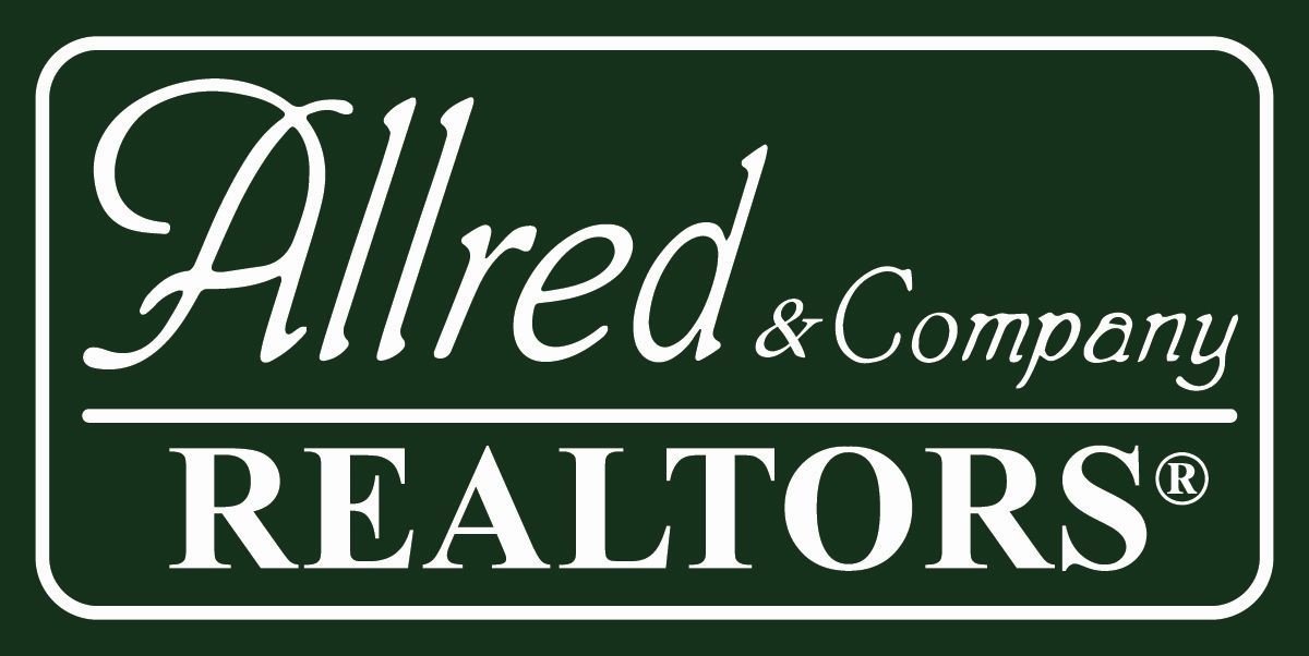 A green and white logo for alfred & company realtors