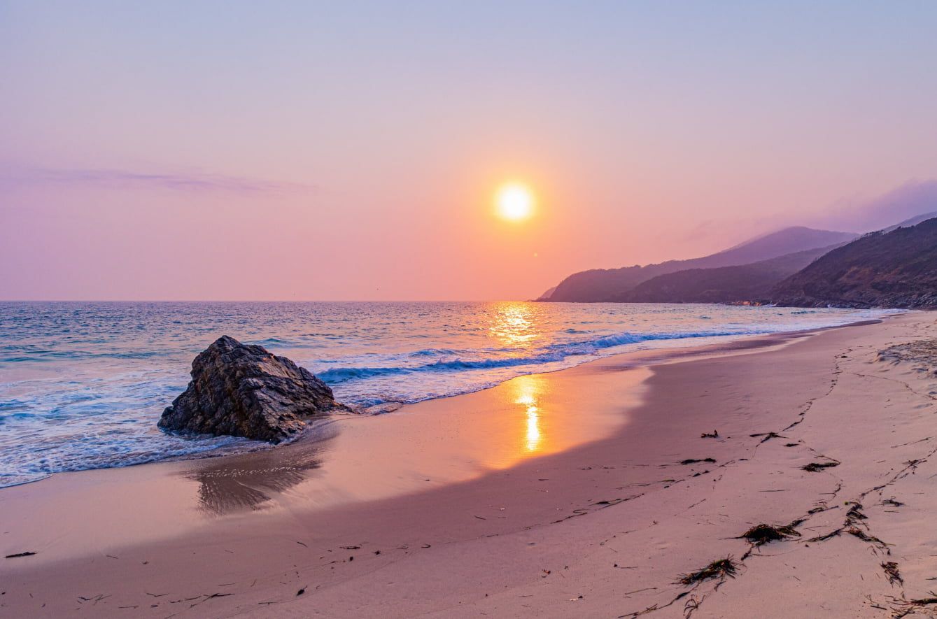 The Sun is Setting Over the Ocean on a Beach — Bali Hi Motel In Forster, NSW