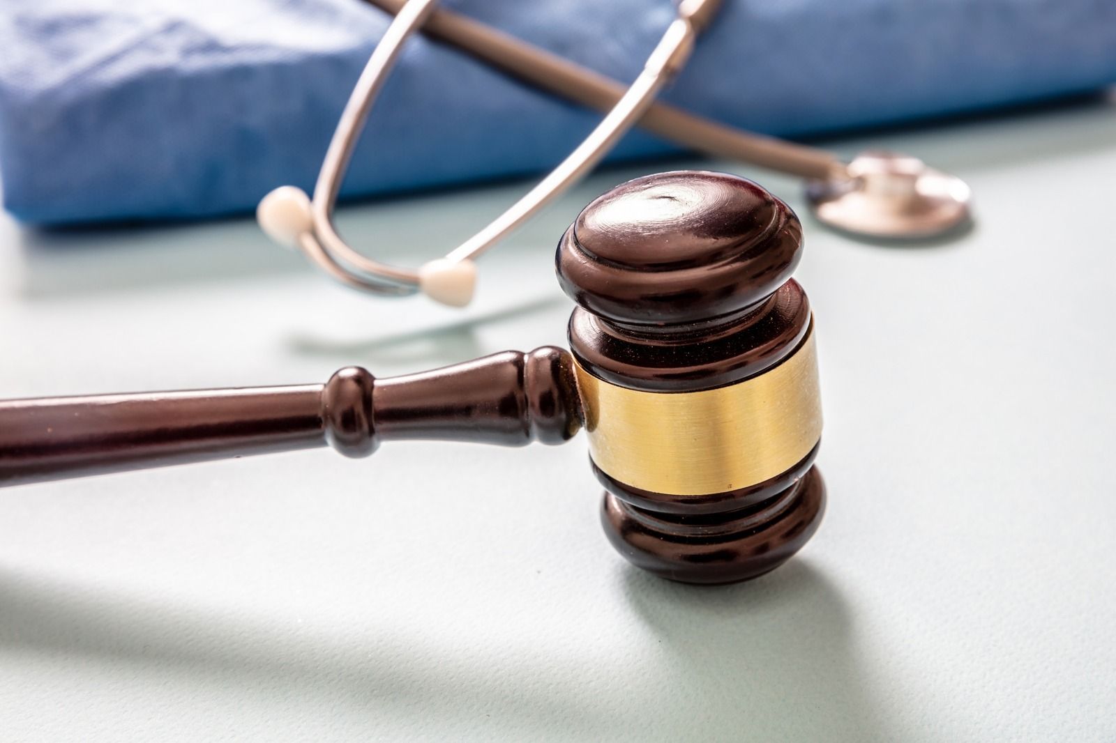 Gavel and notebook on a desk as two people discuss a legal document and take notes