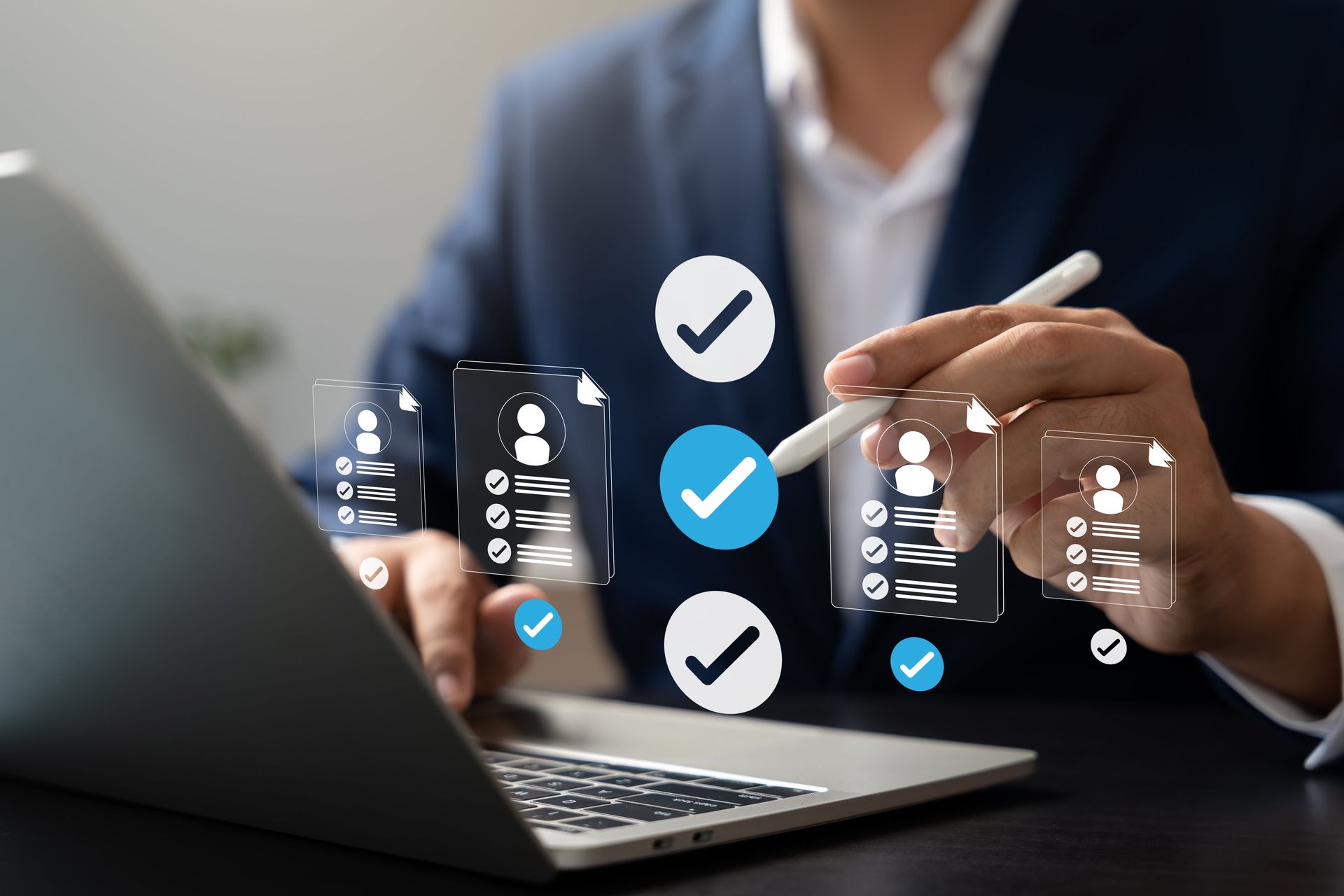 Businessperson using a laptop and tapping floating digital checklist icons on a tablet-like screen