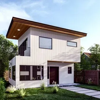 A small white house with a wooden roof and a balcony.