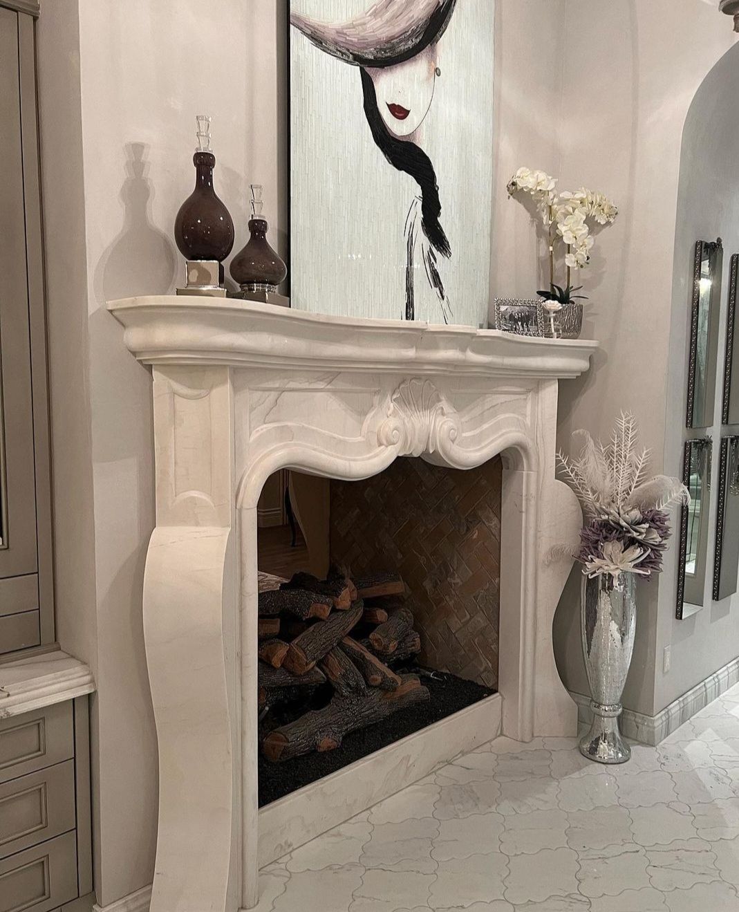 A fireplace with a painting on the wall above it