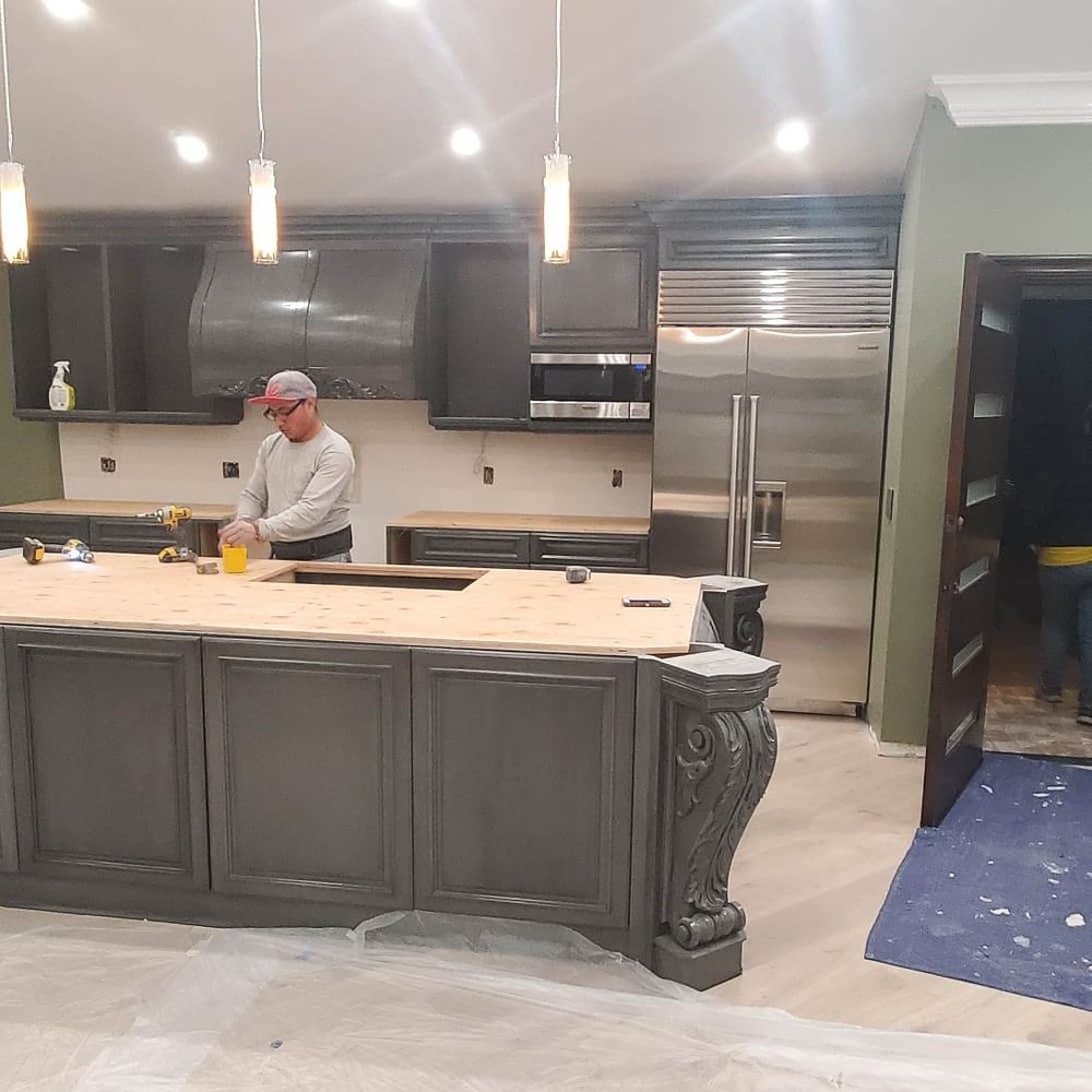 A man is working in a kitchen with stainless steel appliances.
