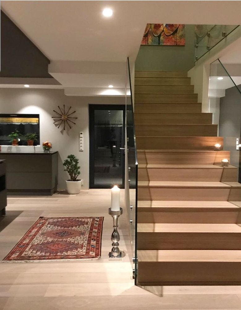 A wooden staircase with a glass railing in a living room