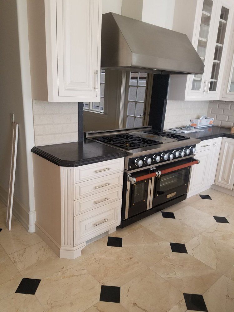 A kitchen with stainless steel appliances and white cabinets.