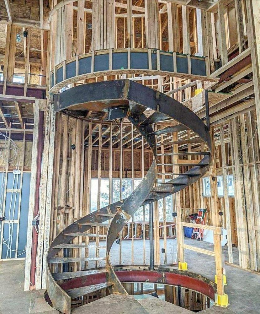 A spiral staircase is being built in a building under construction.