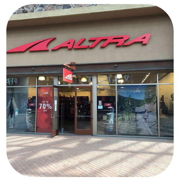 An Altra shoe store storefront with red branding and signage advertising up to 70% off.