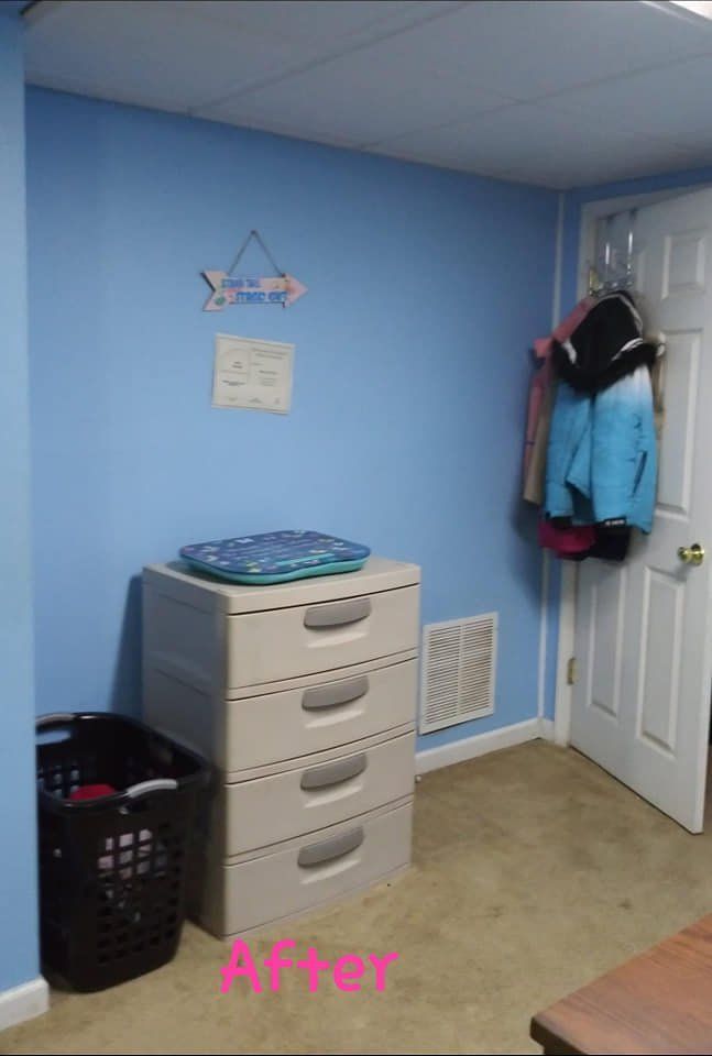 Laundry room after renovation; light blue walls, beige floor, storage drawers, laundry basket, coats on door.