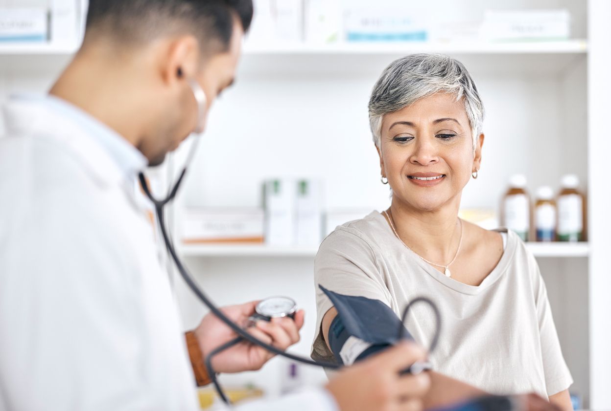 Una mujer realizando una toma de presión en la farmacia