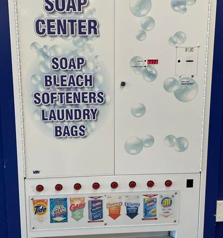 Soap vending machine with bubbles, labeled soap center, soap beach, softeners, and laundry bags.