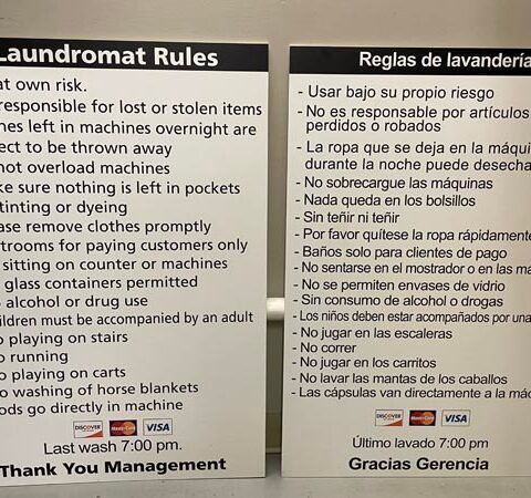 Laundromat rule signs in English and Spanish on dark background with white text and icons.