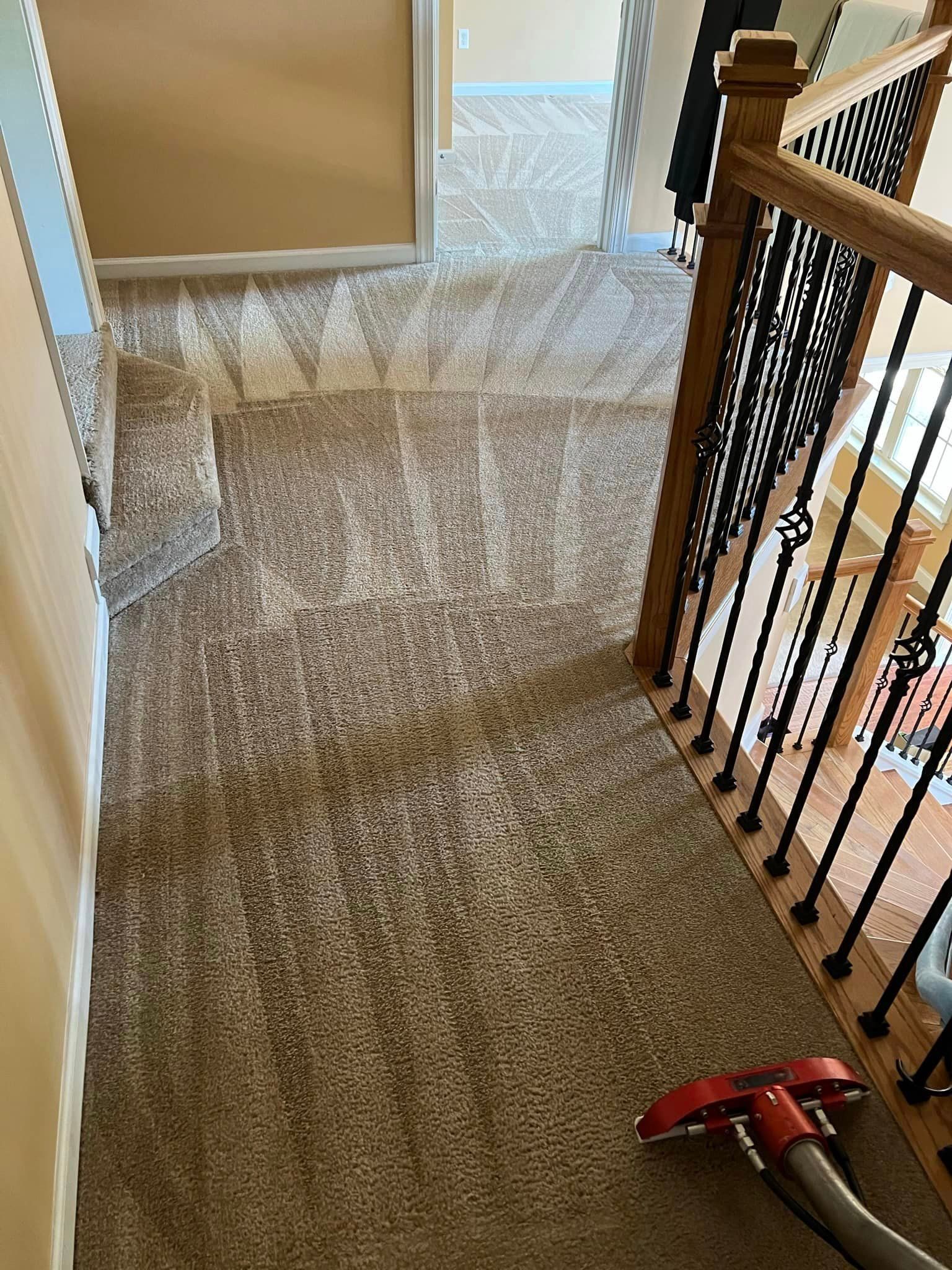 A vacuum cleaner is sitting on the floor next to a staircase in a house.