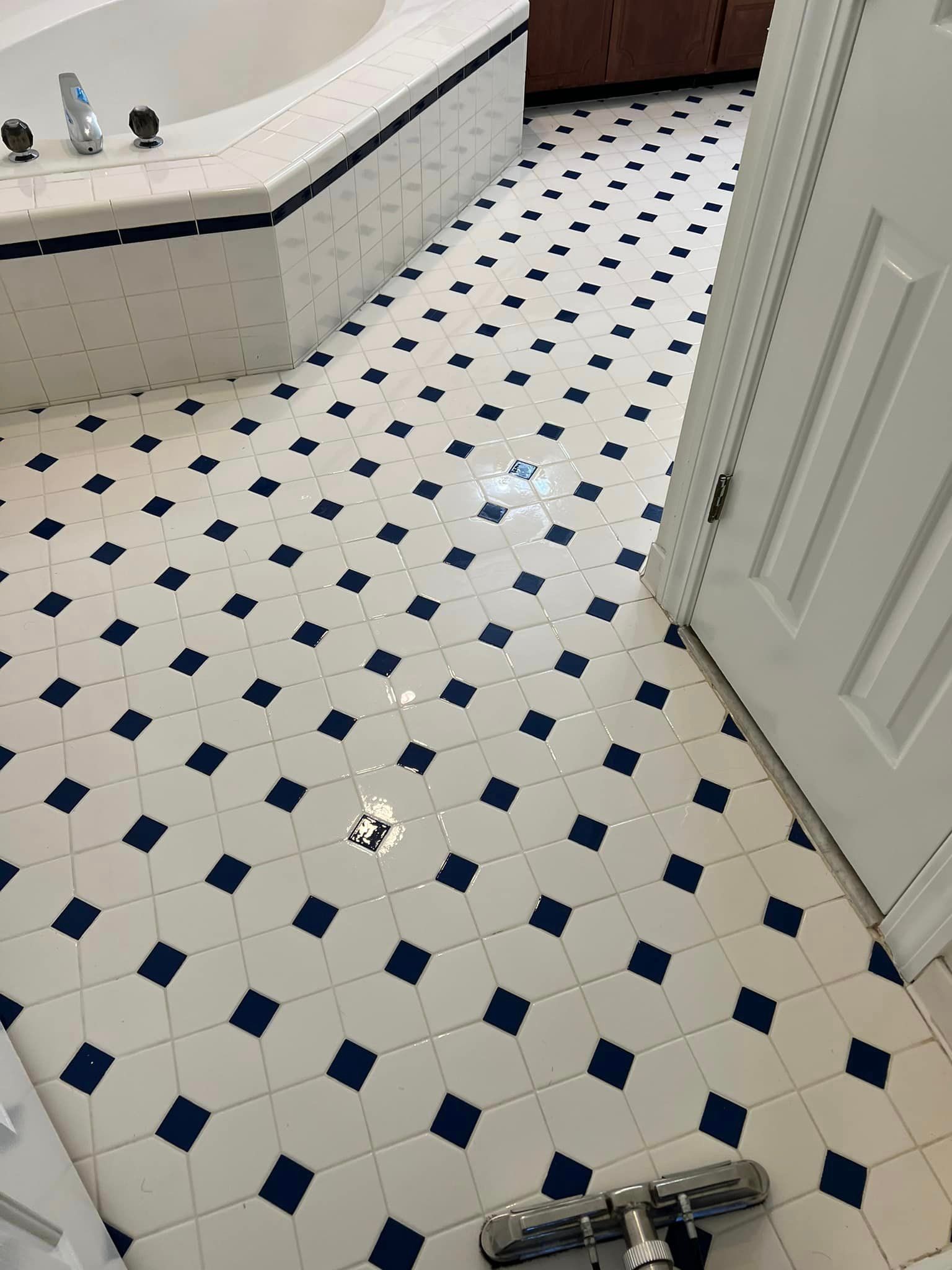 A bathroom with a blue and white checkered floor and a bathtub.