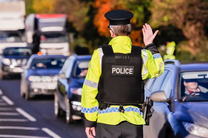 A police officer is standing in the middle of a busy street.